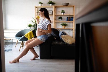 Güzel, genç, hamile bir kadın sağlıklı yemek yiyor.