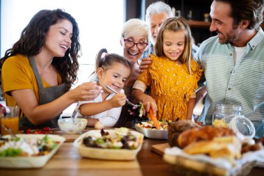 Büyükbabalar, ebeveynler ve çocuklar mutfakta mutlu vakit geçiriyorlar. Aile yemekleri konsepti