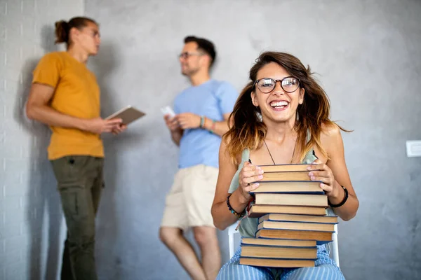 大学生活を楽しんでる 本を持っている美しい幸せな女性と彼の友人と笑顔がバックグラウンドでチャット — ストック写真