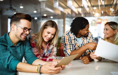 İş adamları iş yerinde eğleniyor, beyin fırtınası yapıyor ve sohbet ediyorlar.