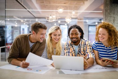 İş adamları, tasarımcılar işyerinde eğleniyor ve sohbet ediyorlar.