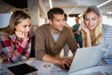 Genç mimar meslektaşları ofiste yeni bir proje üzerinde çalışırken projeleri analiz ediyorlar..