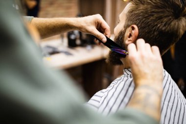 Berber dükkanında kuaförü ziyaret eden mutlu genç adam..