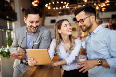 Genç iş adamları işyerinde eğleniyor ve sohbet ediyorlar.