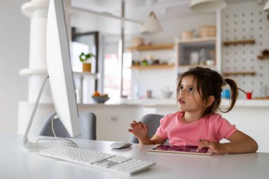 Evde teknoloji aletleriyle oynayan küçük bağımlı çocuk..