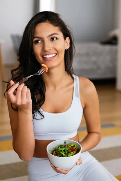 漂亮健康的女人在家锻炼后吃着健康的沙拉 — 图库照片