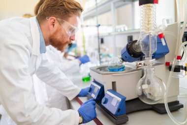 Laboratuvarda test tüpündeki tepkiye bakan bilim adamı..