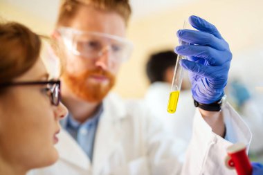 Laboratuvarda çalışan bir grup genç öğrenci ve bilim adamları.