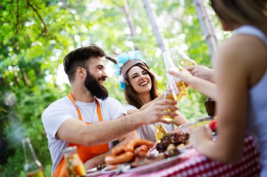 Küçük bir arkadaş grubu alkol içip barbekü partisinde yemek yiyor.