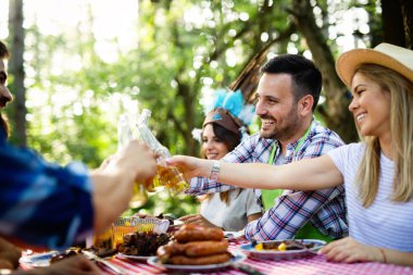 Bir grup genç arkadaş dışarıda barbekü partisi veriyor.