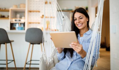 Güzel, mutlu bir kadın tablet kullanıyor, medya içeriğini izliyor. Teknoloji, insanlar konsepti