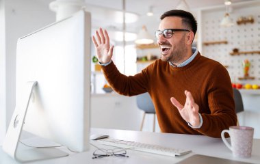 Genç adam bilgisayarla video konferans görüşmesi yapıyor. Uzaktan kumandalı ekip ve evde çalışmak.