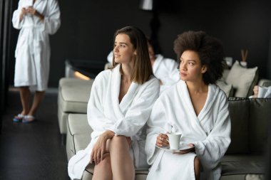 Çekici genç bayan arkadaşlar spa merkezinde kahve içiyorlar.