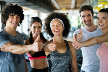 Spor salonunda egzersiz yapan bir grup formda genç.