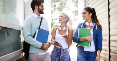 Mutlu öğrenci arkadaş grubu üniversitede açık havada birlikte okuyorlar ve öğreniyorlar.