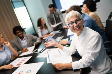 Bir grup iş arkadaşı sunum sırasında toplantı odasında.