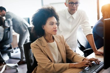 Bir grup genç iş adamı ofiste çalışıyor, beyin fırtınası yapıyor ve iletişim kuruyor.