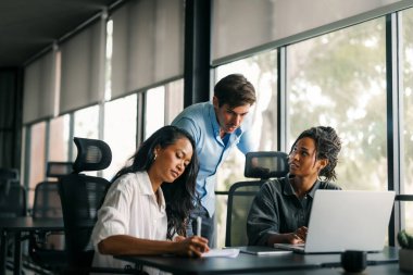 Ofisteki dijital cihazları kullanarak gülümseyen bir yönetici ekibi. Çeşitli profesyonel liderler yöneticiler ve çalışanlar takım çalışmasında çalışan dijital finans projesini tartışıyor.