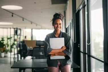 Başarılı mutlu Afro-Amerikan iş kadını, yeni başlayan iş arkadaşı ya da yazılım mühendisi modern bir çalışma alanında çalışıyor.