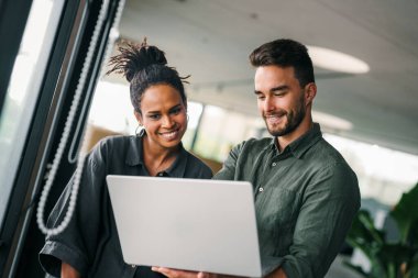 İş projesi ekibi şirket ofisindeki toplantı odasında birlikte çalışıyor.
