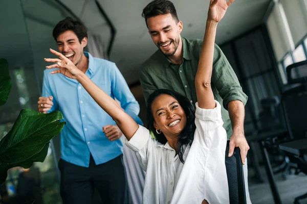 Coşkulu, çeşitli, etnik çeşitlilikte genç meslektaşlar ortak kurumsal başarıyı ya da hedef başarısını kutluyor, modern ofiste kaygısız parti zamanlarının tadını çıkarıyor.