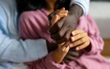 Farklı etnik kökenlere sahip insanlar arasında bir tokalaşma, güveni, uyumu, ait olmayı ve birliği sembolize eder. Mutlu ve dengeli bir çift el ele tutuşuyor..