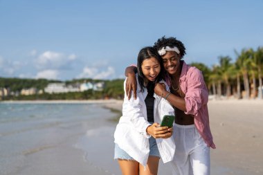 Moda dijital yaratıcısı çift sahilde şık bir selfie çekiyor, sosyal medya için seyahat içeriğini paylaşıyor, cennetteki etkili yaşam tarzını yaşıyorlar.