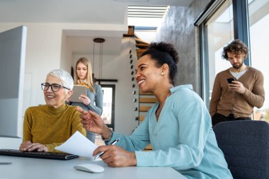 İş çözümleri, teknoloji, başarı ve strateji kavramı. İş arkadaşları ofiste çalışıyor ve beyin fırtınası yapıyorlar.