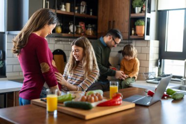 Mutlu aile hafta sonu kahvaltısı sırasında mutfakta eğleniyor. Hamile anne, heyecanlı kızıyla hamileliğinin son üç ayının tadını çıkarıyor..