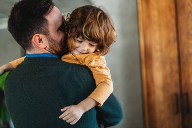 Mutlu bir baba, bekar bir baba ve sevimli bir çocuk oyun oynuyor, gülüyor, evde eğleniyor. Aile eğlence konsepti