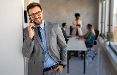 Modern bir ofiste, başarılı bir iş adamı telefon iletişimi, liderlik, strateji ve profesyonel hırsı gösteren birden fazla iş yapar.