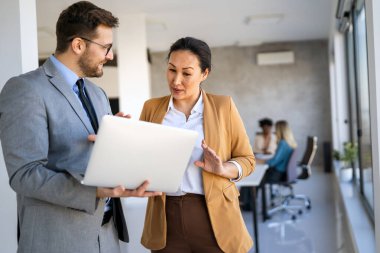 Tam konsantrasyon. Takım olarak çalışan ve kurumsal ofiste iletişim kuran bir grup genç iş adamı.