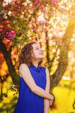 Çiçek bahçesinde bir yolda neşeli genç kız.