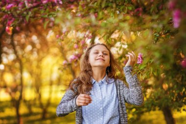 Çiçek bahçesinde bir yolda neşeli genç kız.