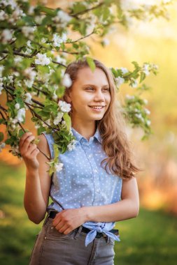 Çiçek bahçesinde bir yolda neşeli genç kız.