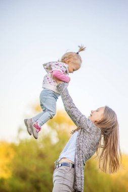 Kız parkta çayırda eğleniyor.