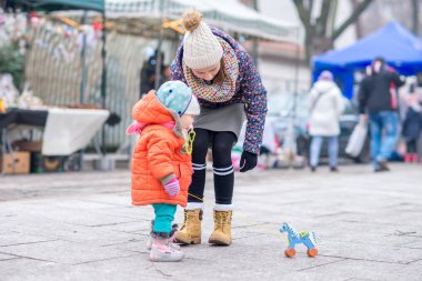 Çocuk ve ablası sokak soğuk havalarda tahtadan bir at ile oynamak.