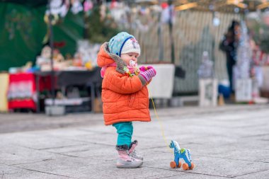 Çocuk sokakta soğuk havalarda tahtadan bir at ile çalış.