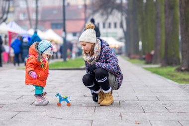 Çocuk ve ablası sokak soğuk havalarda tahtadan bir at ile oynamak.