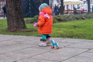Çocuk sokakta soğuk havalarda tahtadan bir at ile çalış.