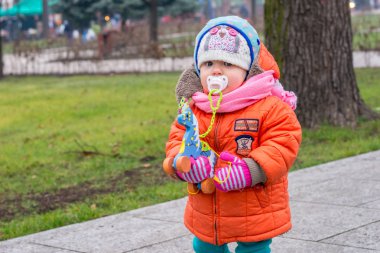 Çocuk sokakta soğuk havalarda tahtadan bir at ile çalış.