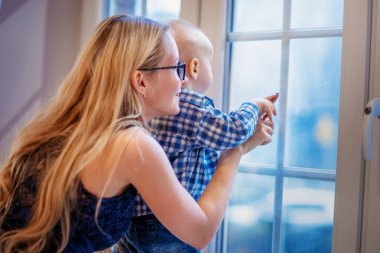 Anne bebek çocuk pencereden dışarı bakarak ile.