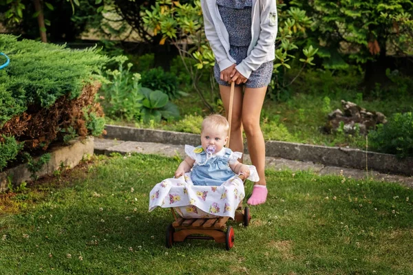 Kid Sitting Wooden Cart His Older Sister Rolls Summer Garden — Stock Photo, Image