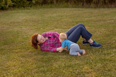 Bebek annesiyle çimenlerin üzerinde oynarken ilk yıl.
