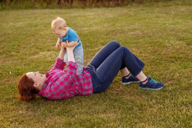 Bebek annesiyle çimenlerin üzerinde oynarken ilk yıl.