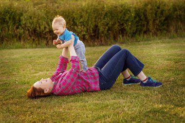 Annesi ile çim üzerinde oynayan bebek eğlence.