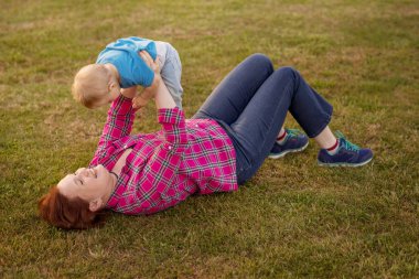 Bebek annesiyle çimenlerin üzerinde oynarken ilk yıl.