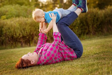 Annesi ile çim üzerinde oynayan bebek eğlence.