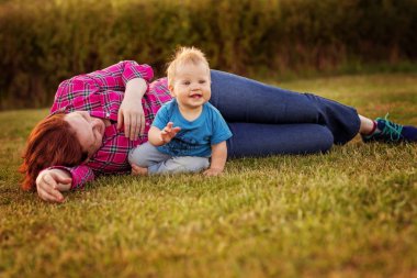 Bebek annesiyle çimenlerin üzerinde oynarken ilk yıl.