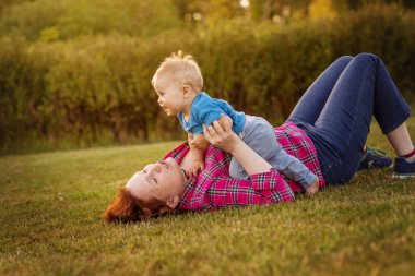 Annesi ile çim üzerinde oynayan bebek eğlence.